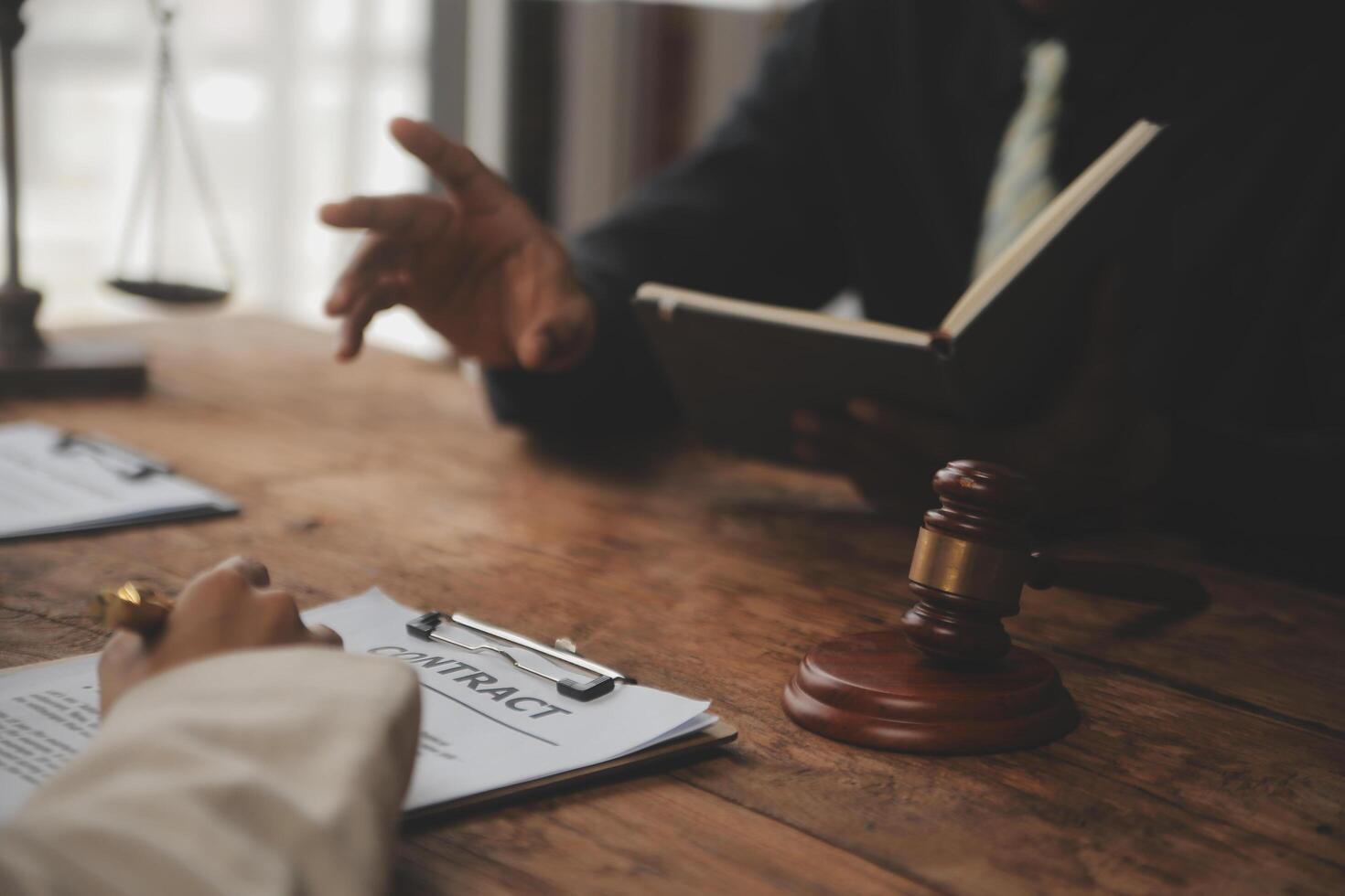 Business and lawyers discussing contract papers with brass scale on desk in office. Law, legal services, advice, justice and law concept picture with film grain effect photo