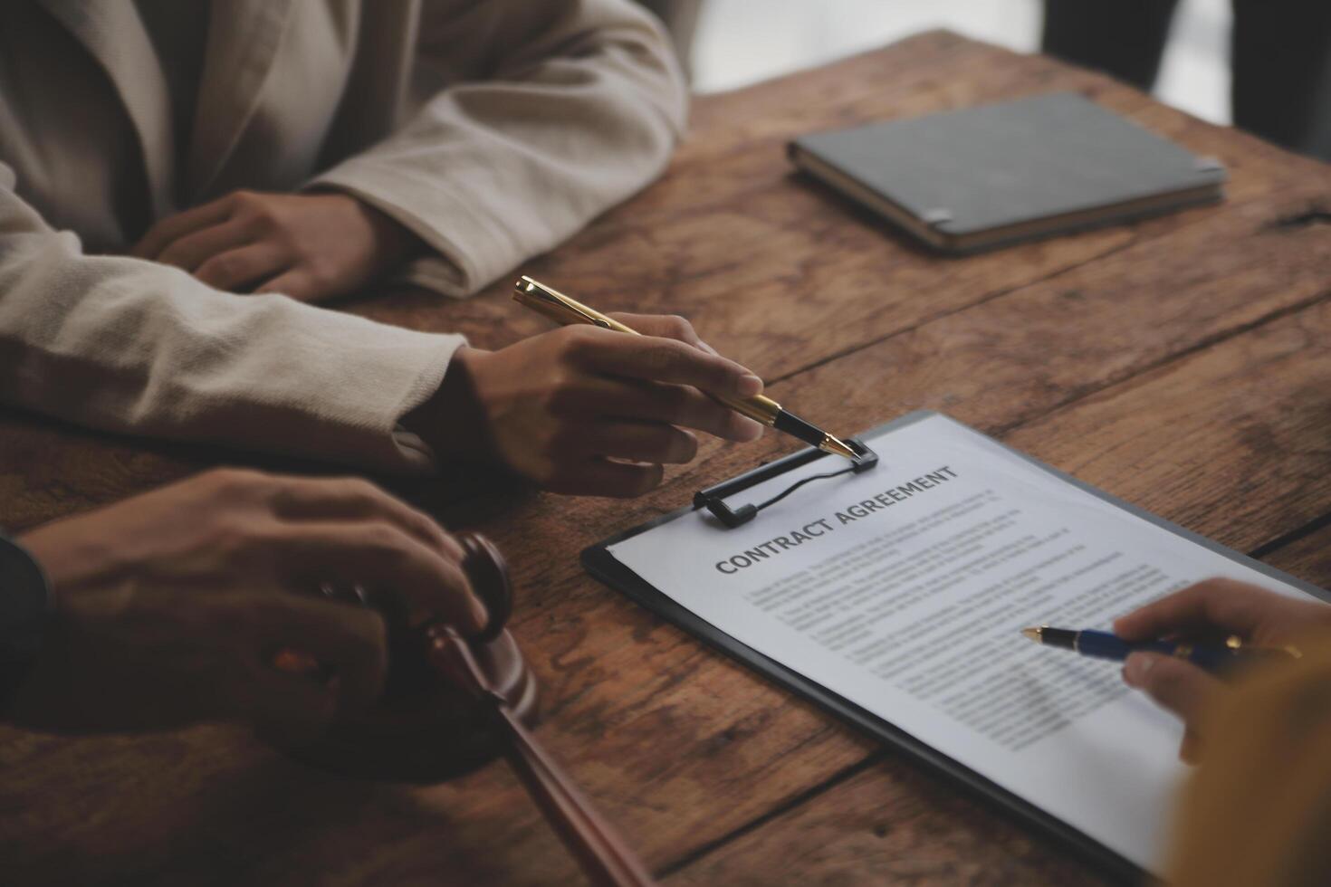 Business and lawyers discussing contract papers with brass scale on desk in office. Law, legal services, advice, justice and law concept picture with film grain effect photo