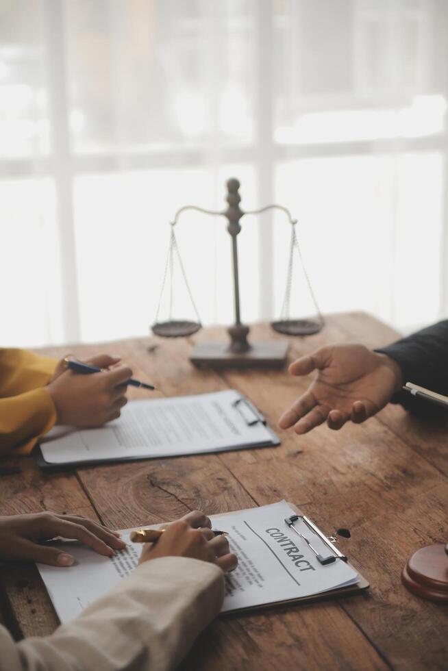 Business and lawyers discussing contract papers with brass scale on desk in office. Law, legal services, advice, justice and law concept picture with film grain effect photo