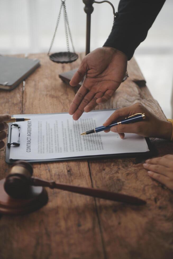 Business and lawyers discussing contract papers with brass scale on desk in office. Law, legal services, advice, justice and law concept picture with film grain effect photo