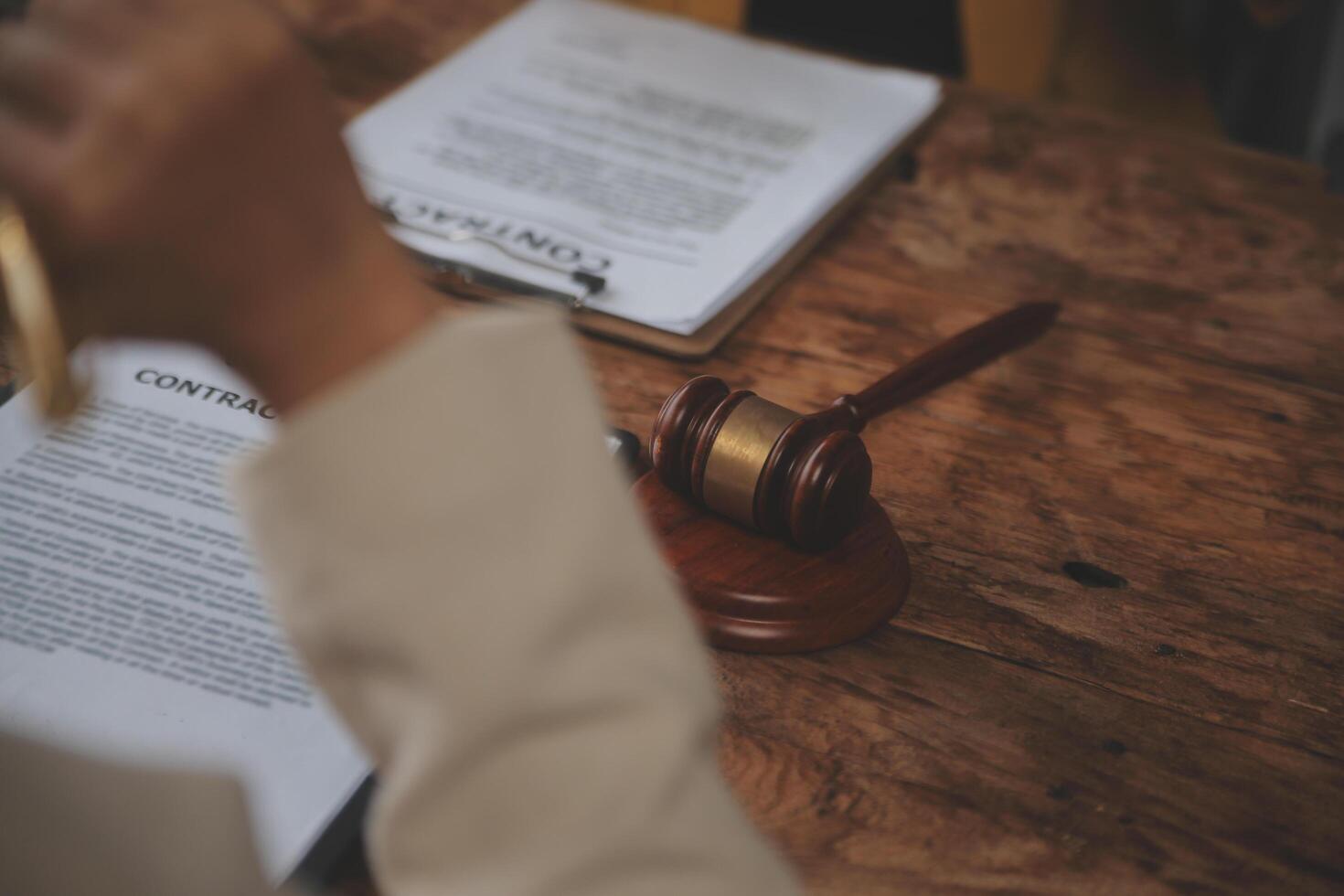 Business and lawyers discussing contract papers with brass scale on desk in office. Law, legal services, advice, justice and law concept picture with film grain effect photo