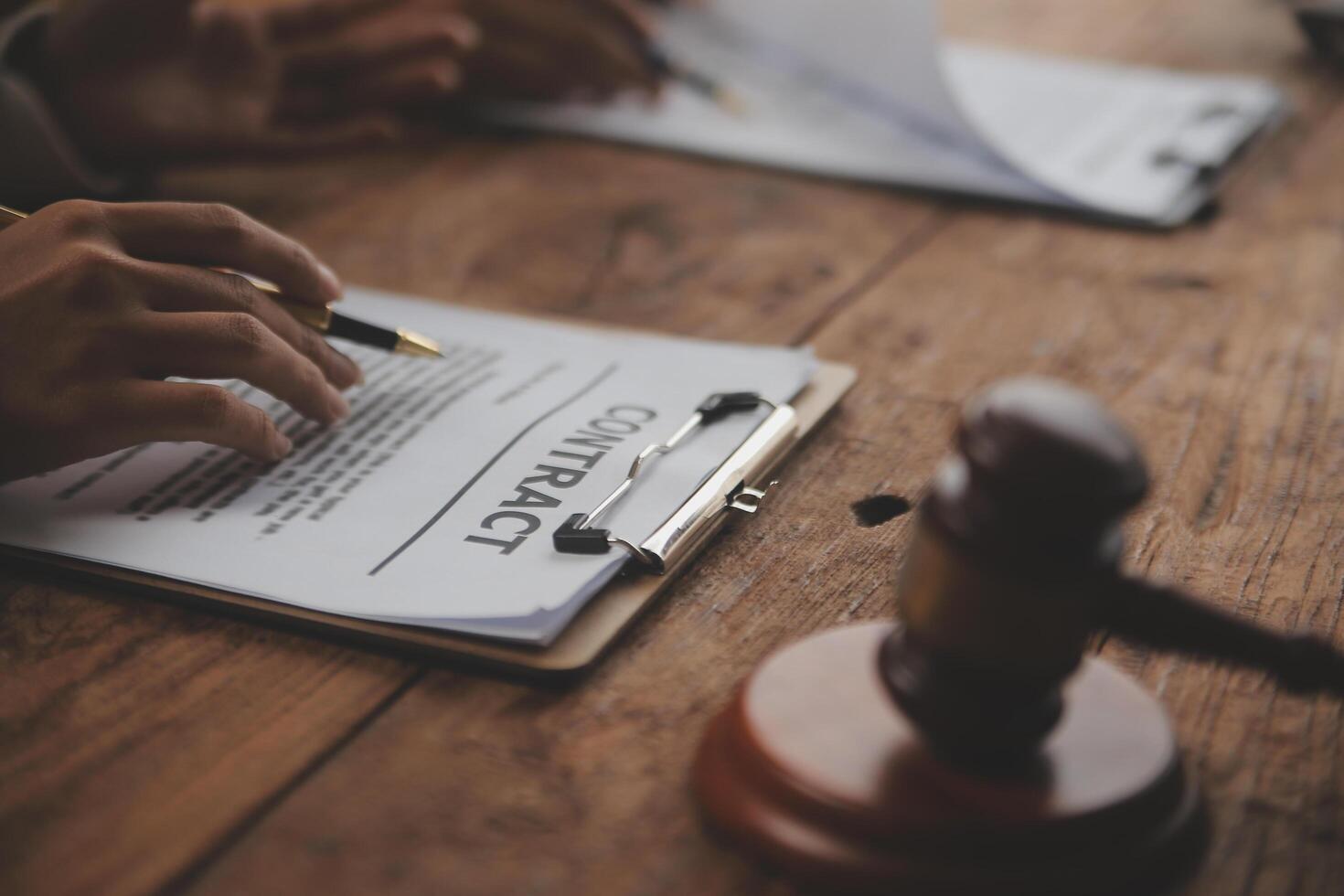 Business and lawyers discussing contract papers with brass scale on desk in office. Law, legal services, advice, justice and law concept picture with film grain effect photo