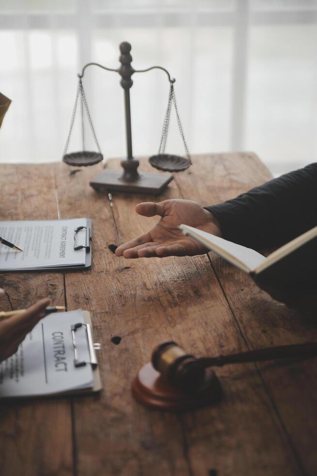 Business and lawyers discussing contract papers with brass scale on desk in office. Law, legal services, advice, justice and law concept picture with film grain effect photo