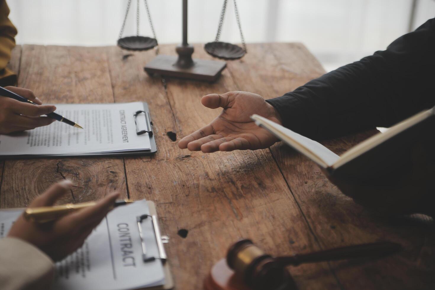 Business and lawyers discussing contract papers with brass scale on desk in office. Law, legal services, advice, justice and law concept picture with film grain effect photo