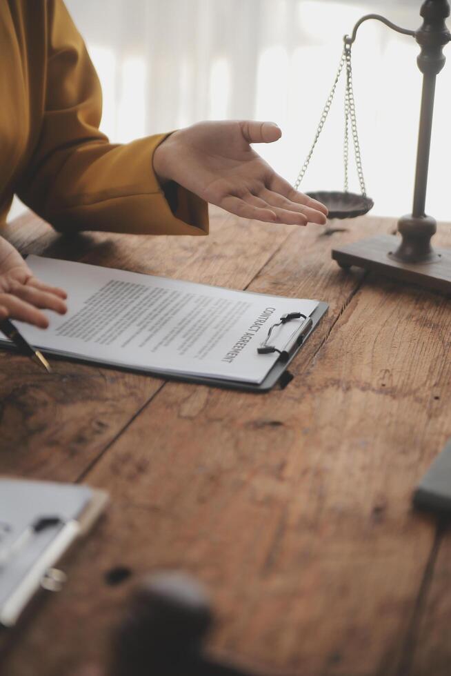 Business and lawyers discussing contract papers with brass scale on desk in office. Law, legal services, advice, justice and law concept picture with film grain effect photo