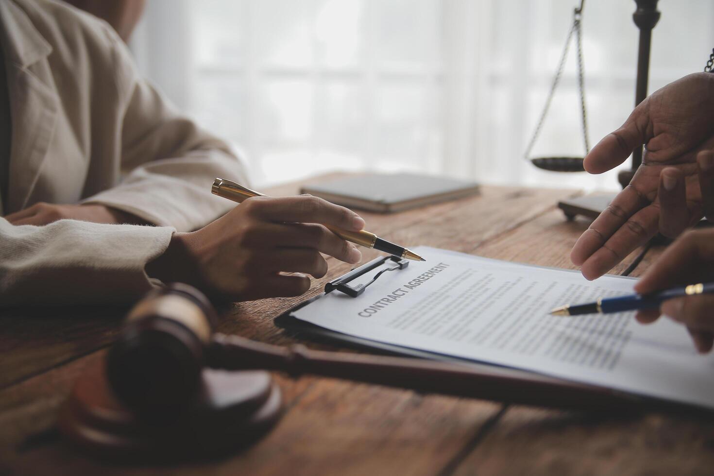 Business and lawyers discussing contract papers with brass scale on desk in office. Law, legal services, advice, justice and law concept picture with film grain effect photo