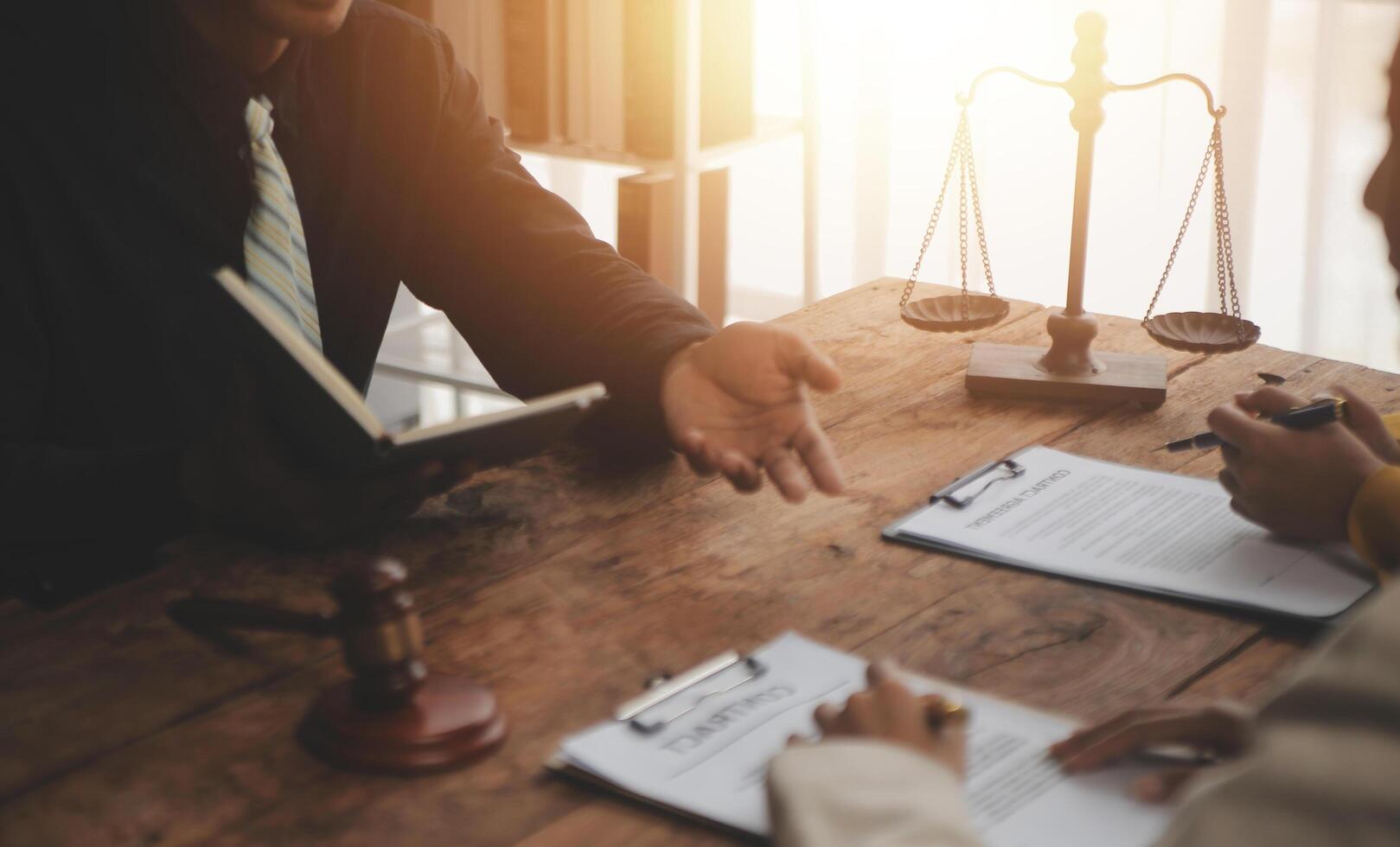 Business and lawyers discussing contract papers with brass scale on desk in office. Law, legal services, advice, justice and law concept picture with film grain effect photo