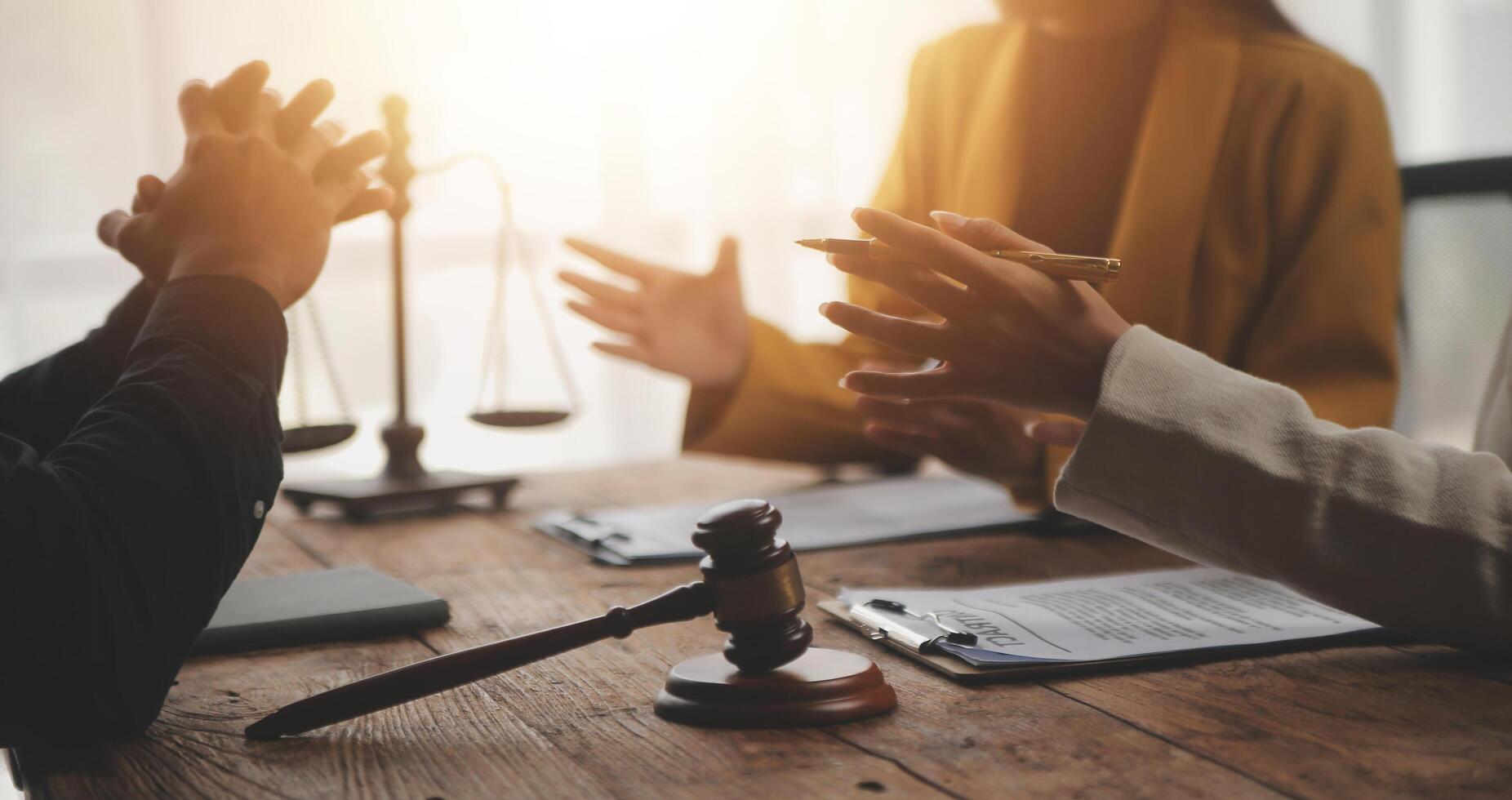 Business and lawyers discussing contract papers with brass scale on desk in office. Law, legal services, advice, justice and law concept picture with film grain effect photo