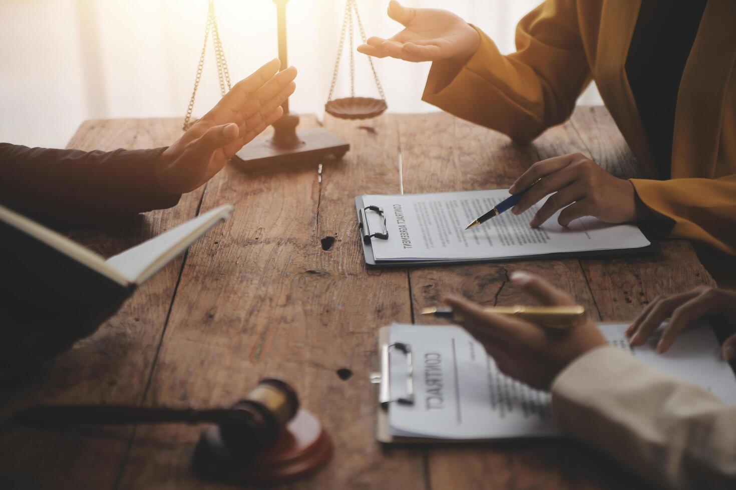 Business and lawyers discussing contract papers with brass scale on desk in office. Law, legal services, advice, justice and law concept picture with film grain effect photo