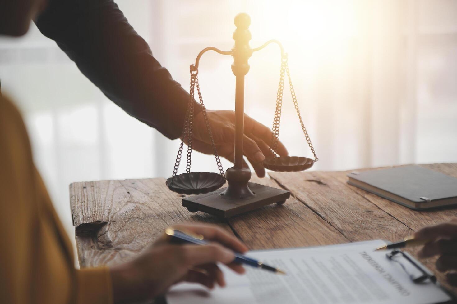 Business and lawyers discussing contract papers with brass scale on desk in office. Law, legal services, advice, justice and law concept picture with film grain effect photo