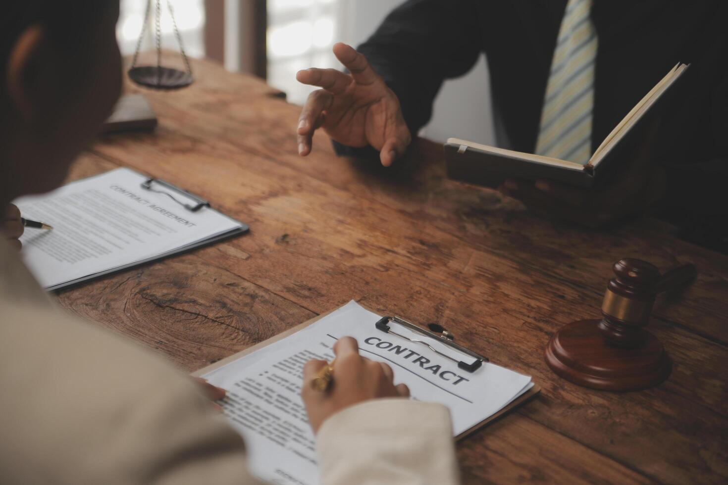 Business and lawyers discussing contract papers with brass scale on desk in office. Law, legal services, advice, justice and law concept picture with film grain effect photo