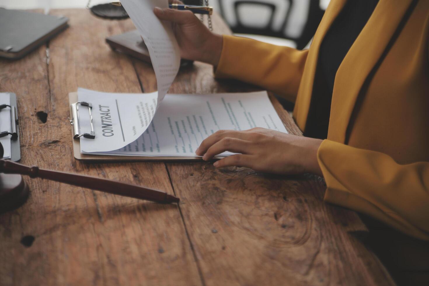 Business and lawyers discussing contract papers with brass scale on desk in office. Law, legal services, advice, justice and law concept picture with film grain effect photo