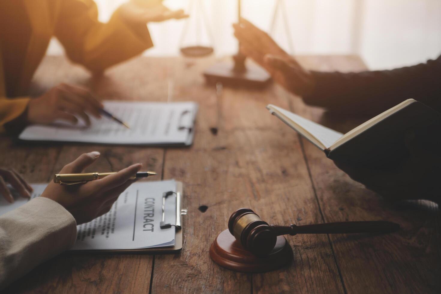 Business and lawyers discussing contract papers with brass scale on desk in office. Law, legal services, advice, justice and law concept picture with film grain effect photo