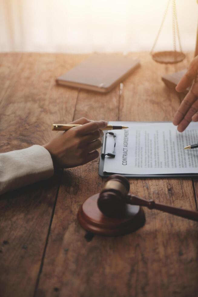Business and lawyers discussing contract papers with brass scale on desk in office. Law, legal services, advice, justice and law concept picture with film grain effect photo
