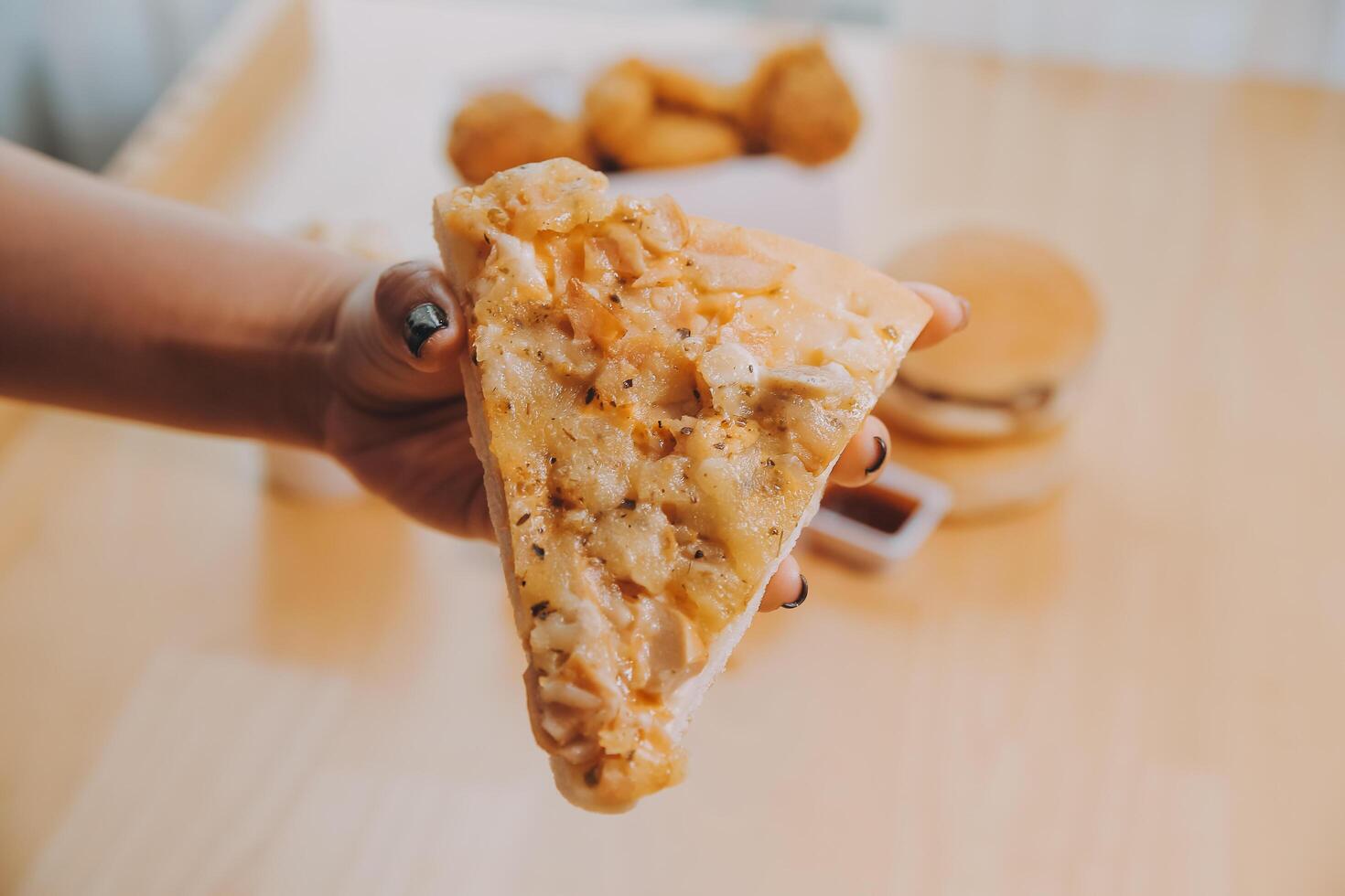 Cropped image of woman holding pizza slice at restaurant photo