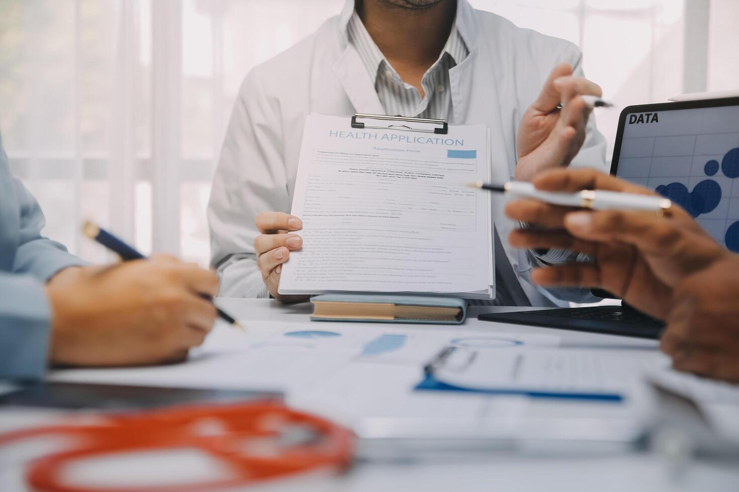Meeting, tablet and team of doctors with collaboration for healthcare talk and telehealth app in office. Surgeon group, tech and medical discussion with website for hospital funding or sponsorship photo