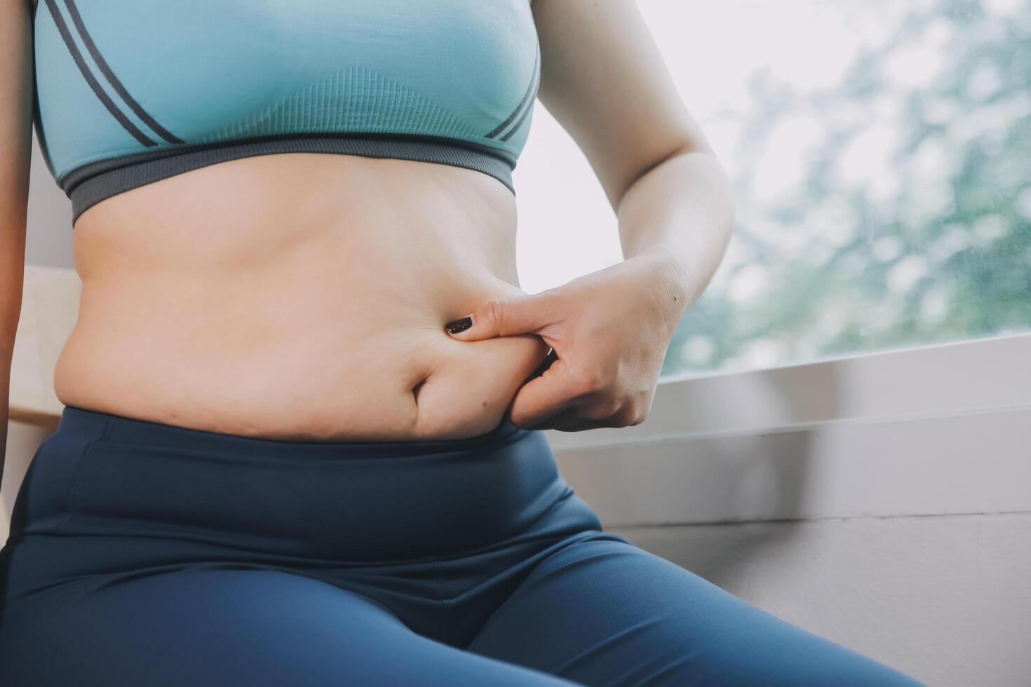 fat woman, fat belly, chubby, obese woman hand holding excessive belly fat with measure tape, woman diet lifestyle concept photo