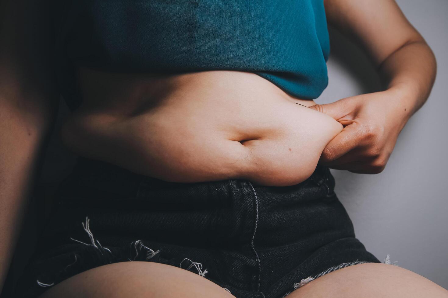 fat woman, fat belly, chubby, obese woman hand holding excessive belly fat with measure tape, woman diet lifestyle concept photo