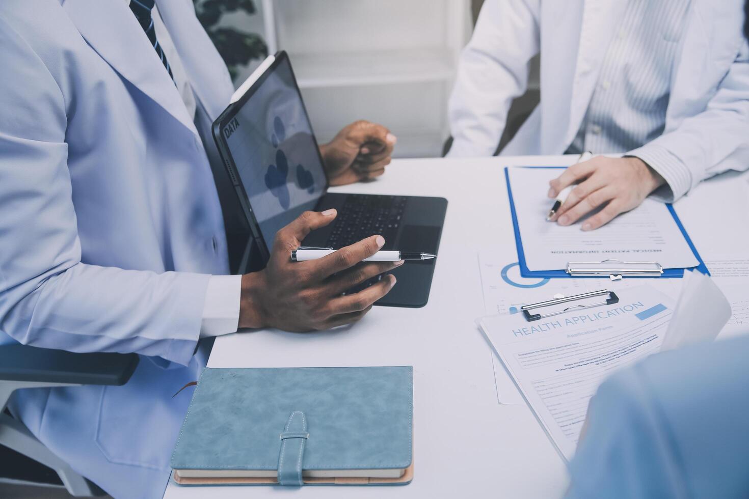 Meeting, tablet and team of doctors with collaboration for healthcare talk and telehealth app in office. Surgeon group, tech and medical discussion with website for hospital funding or sponsorship photo