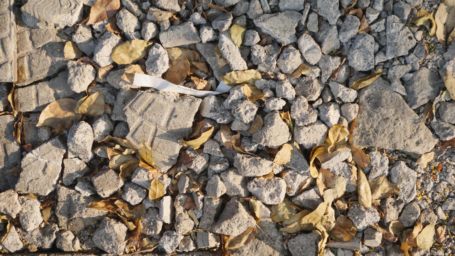 crushed stone on the ground with fallen leaves in the autumn season. photo