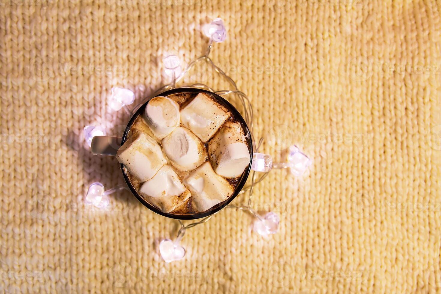 Ceramic mug with hot fresh cocoa drink with marshmallow on soft pink background. photo