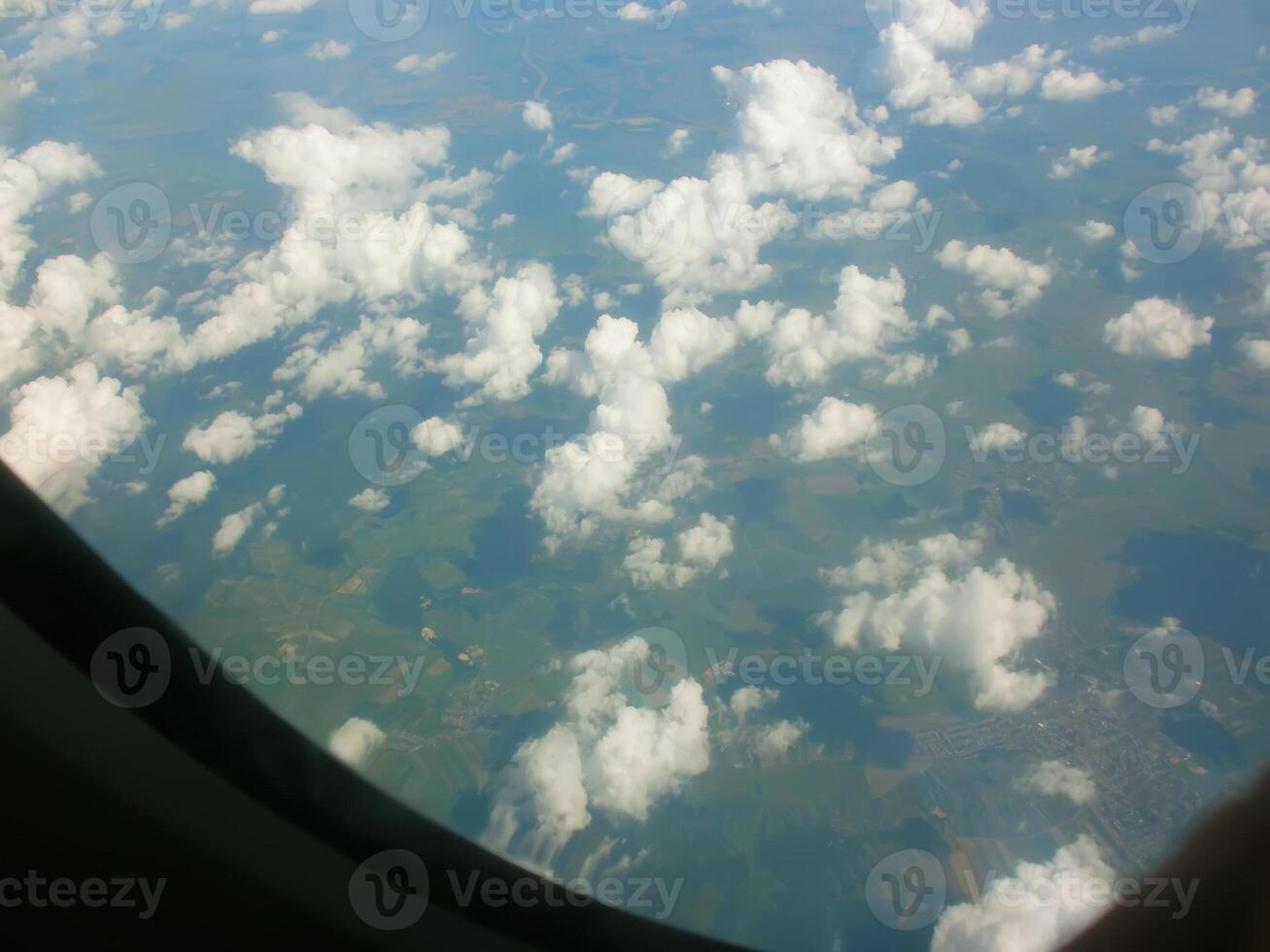 View from airplane window. White clouds above the land. photo