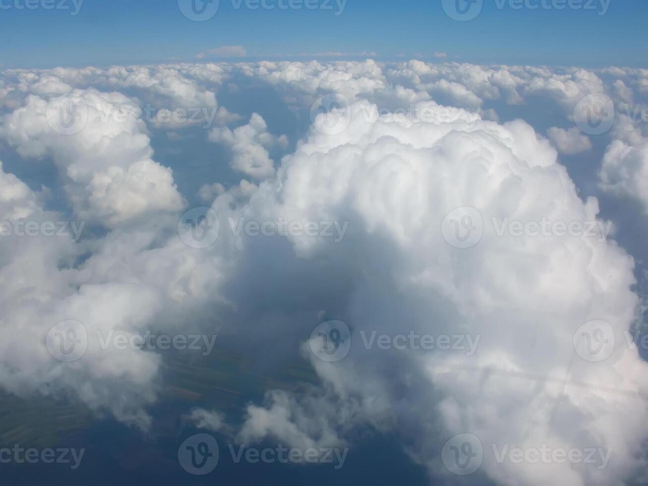 View from airplane window. White clouds above the land. photo