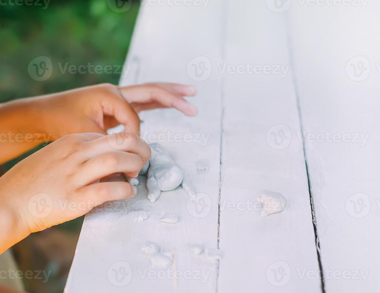 Kid hands in the process of creating the handicraft of polymer clay photo