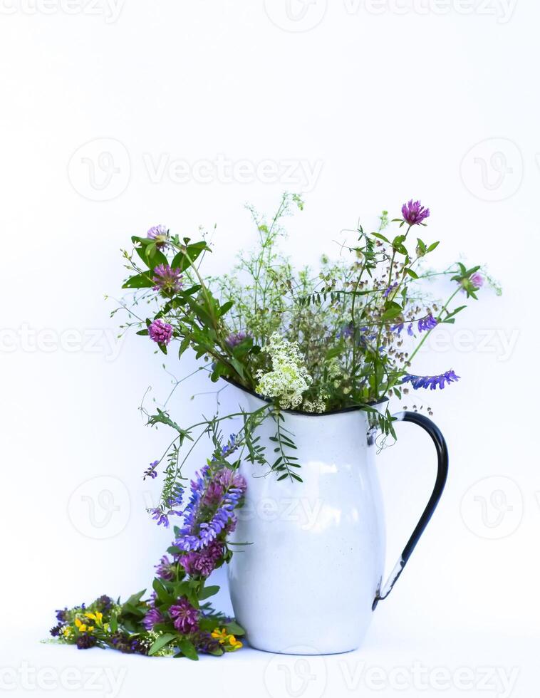 A bouquet of wildflowers in metal jug. Floral decor. photo