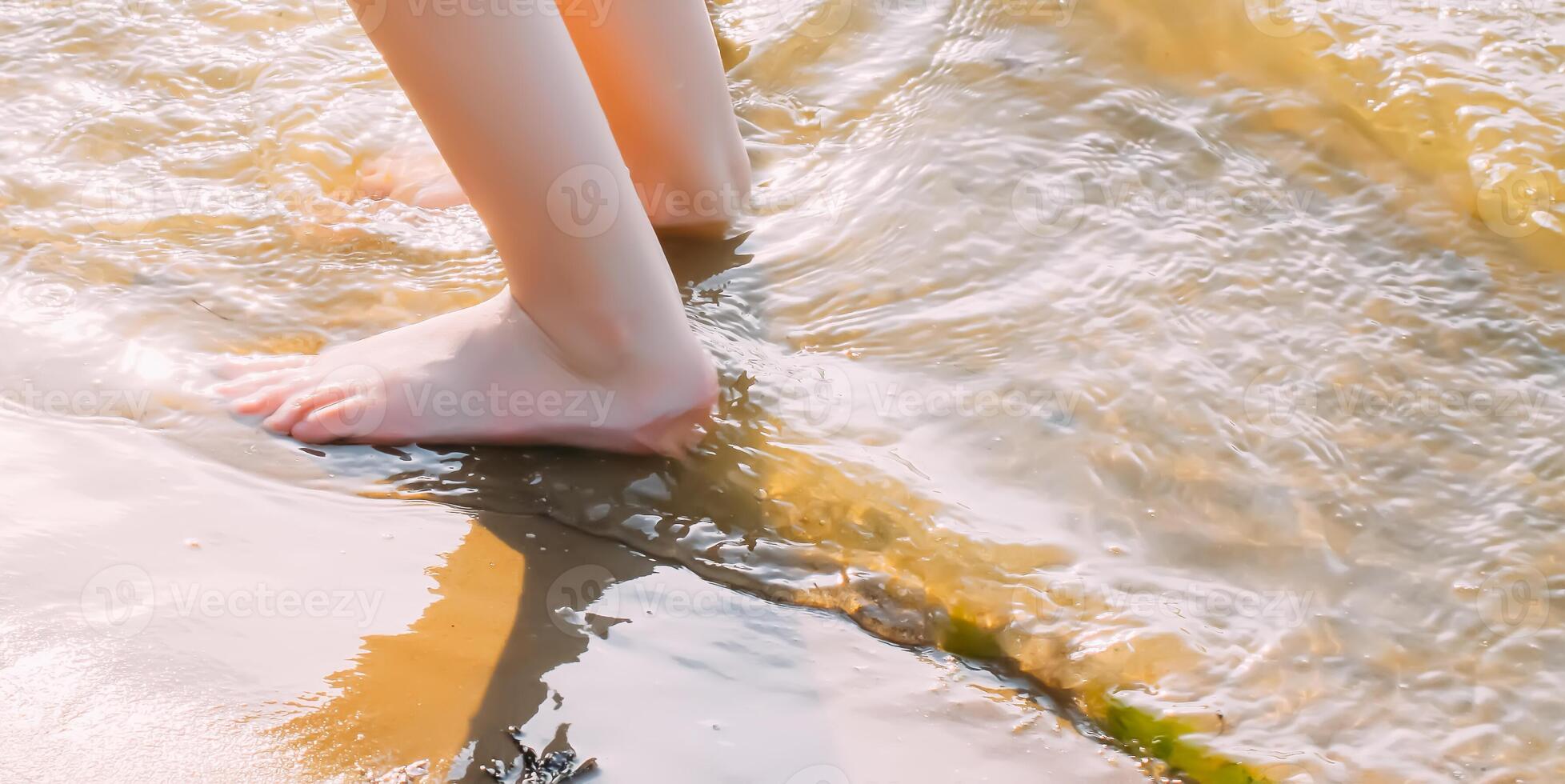 Child's bare feet walking at a beach. photo