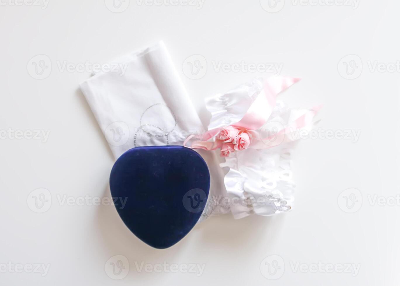 Engagement ring box on white background and a garter from the bride's stocking. photo