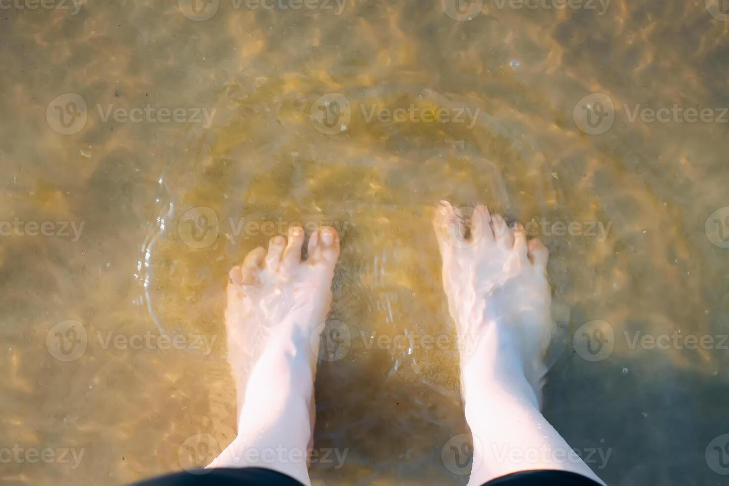 Woman's bare feet walking at a beach. photo