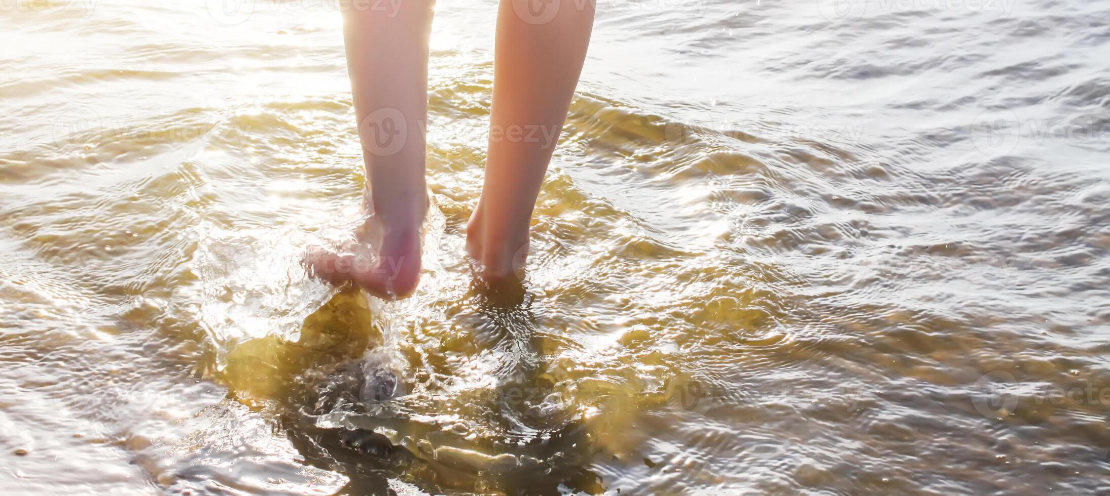 Child's bare feet walking at a beach. photo