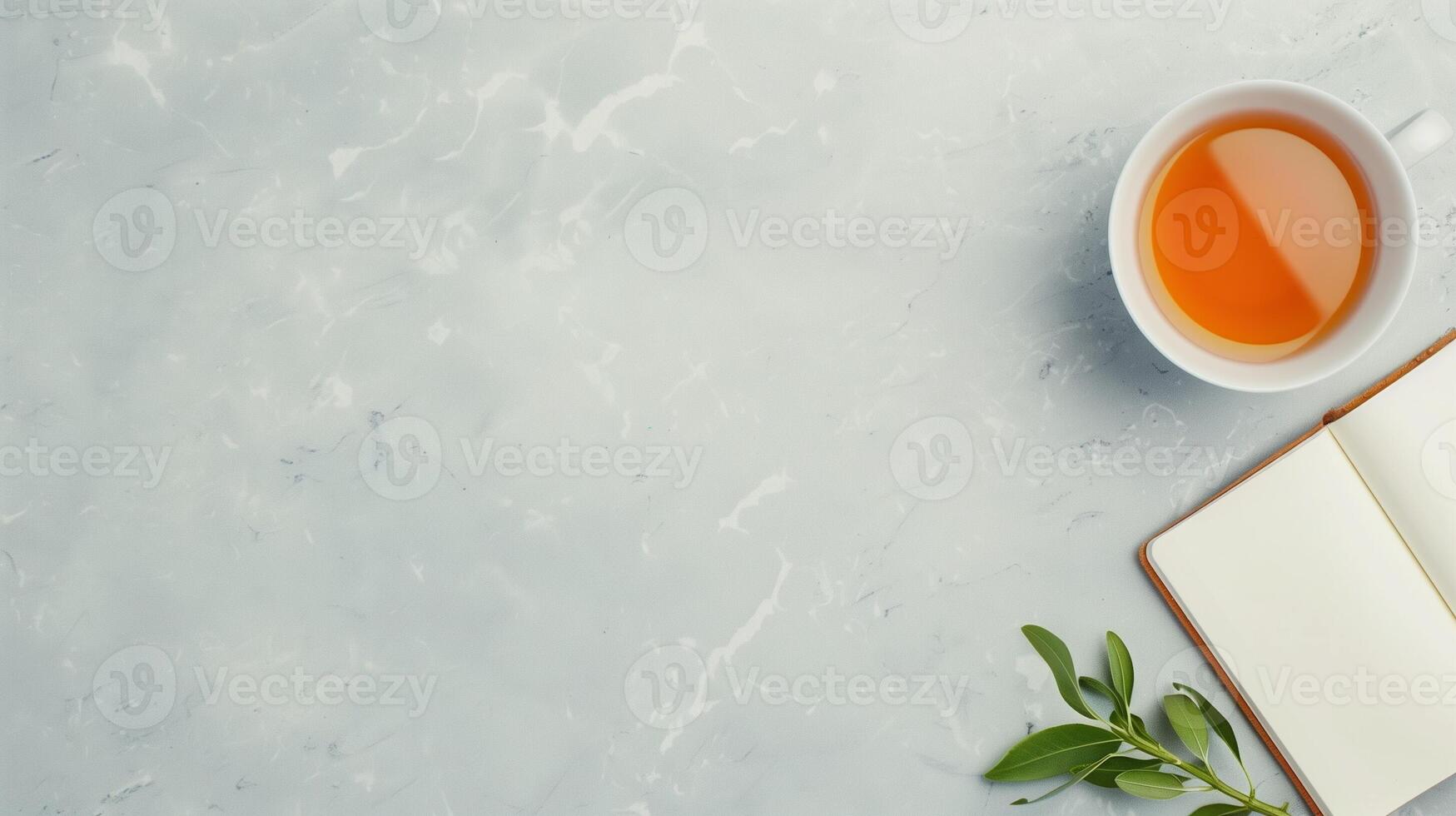 Tranquil Workspace Featuring a Cup of Herbal Tea and Open Notebook on Marble Surface with Green Leaves for Relaxed Productivity and Inspiration photo