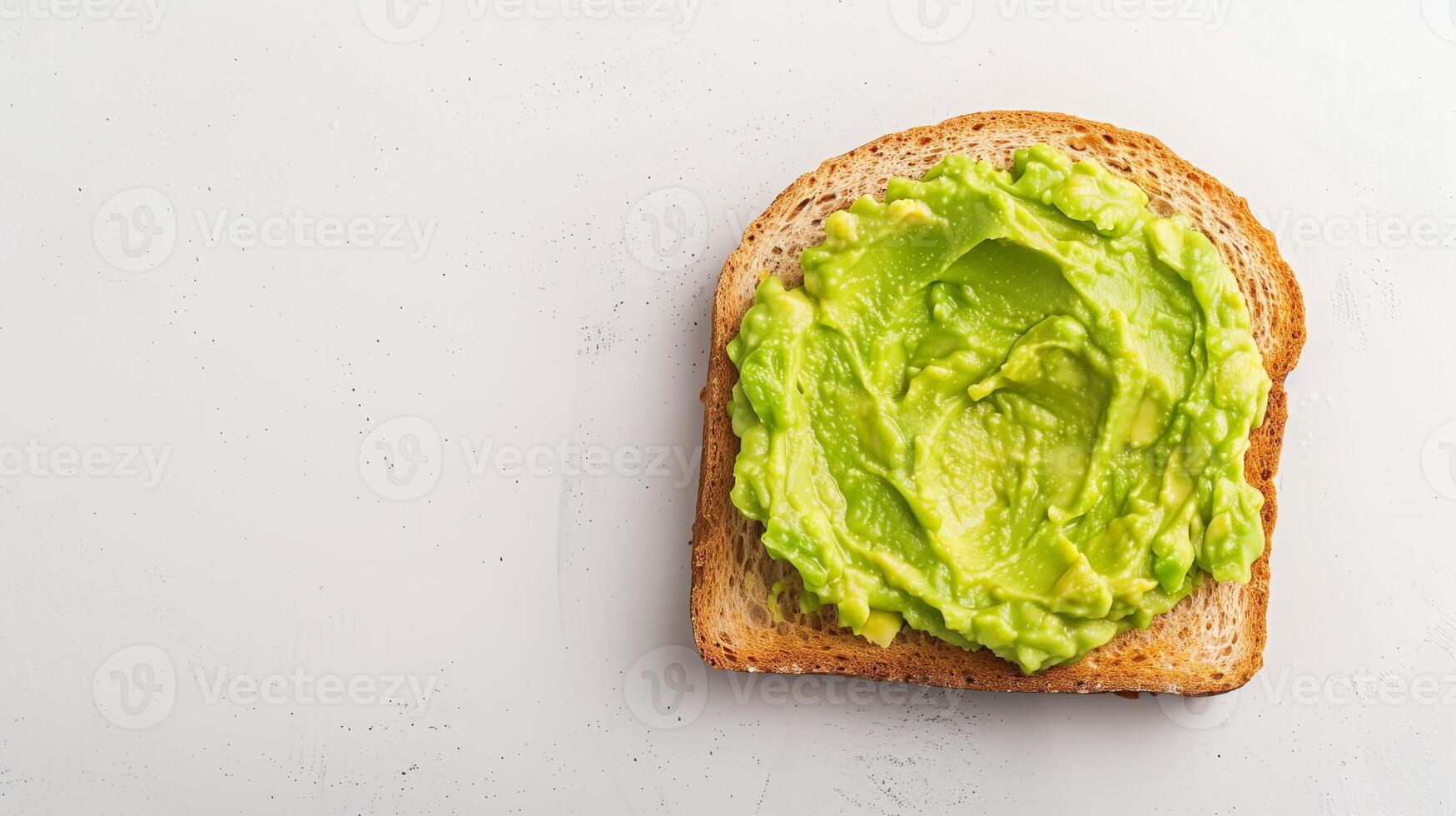 Single Slice of Toast with Fresh Mashed Avocado on White Background Healthy Breakfast Snack Photo