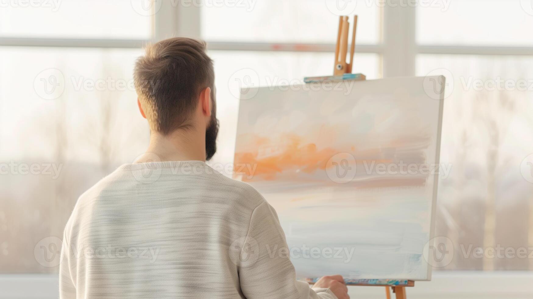 A Thoughtful Artist Painting a Serene Landscape in a Sunlit Studio with Soft Pastel Colors on a Canvas, Concept of Creativity and Artistry in Tranquil Setting photo