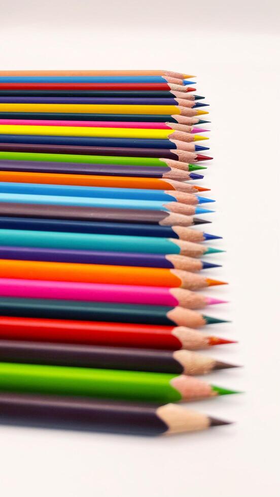 Colorful sharpened pencils are lined up on the table. photo