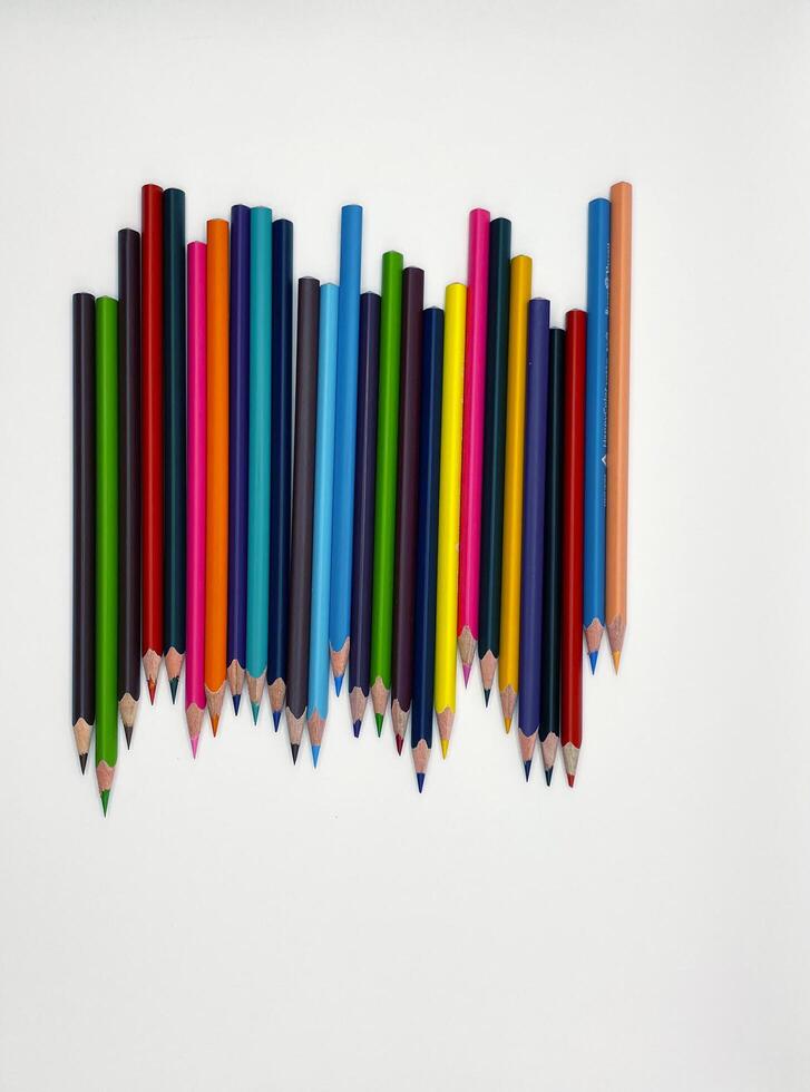 Colorful sharpened pencils are lined up on the table. photo