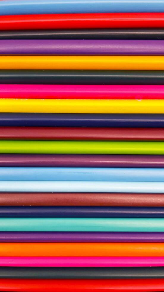 Colorful sharpened pencils are lined up on the table. photo