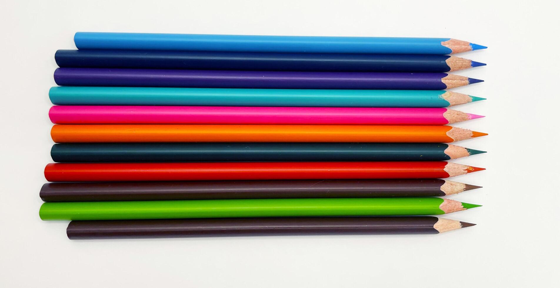 Colorful sharpened pencils are lined up on the table. photo