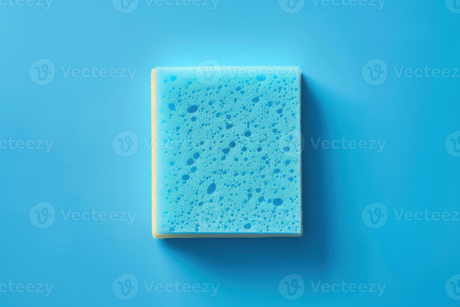 A blue sponge resting on a light blue surface, emphasizing its texture and design photo