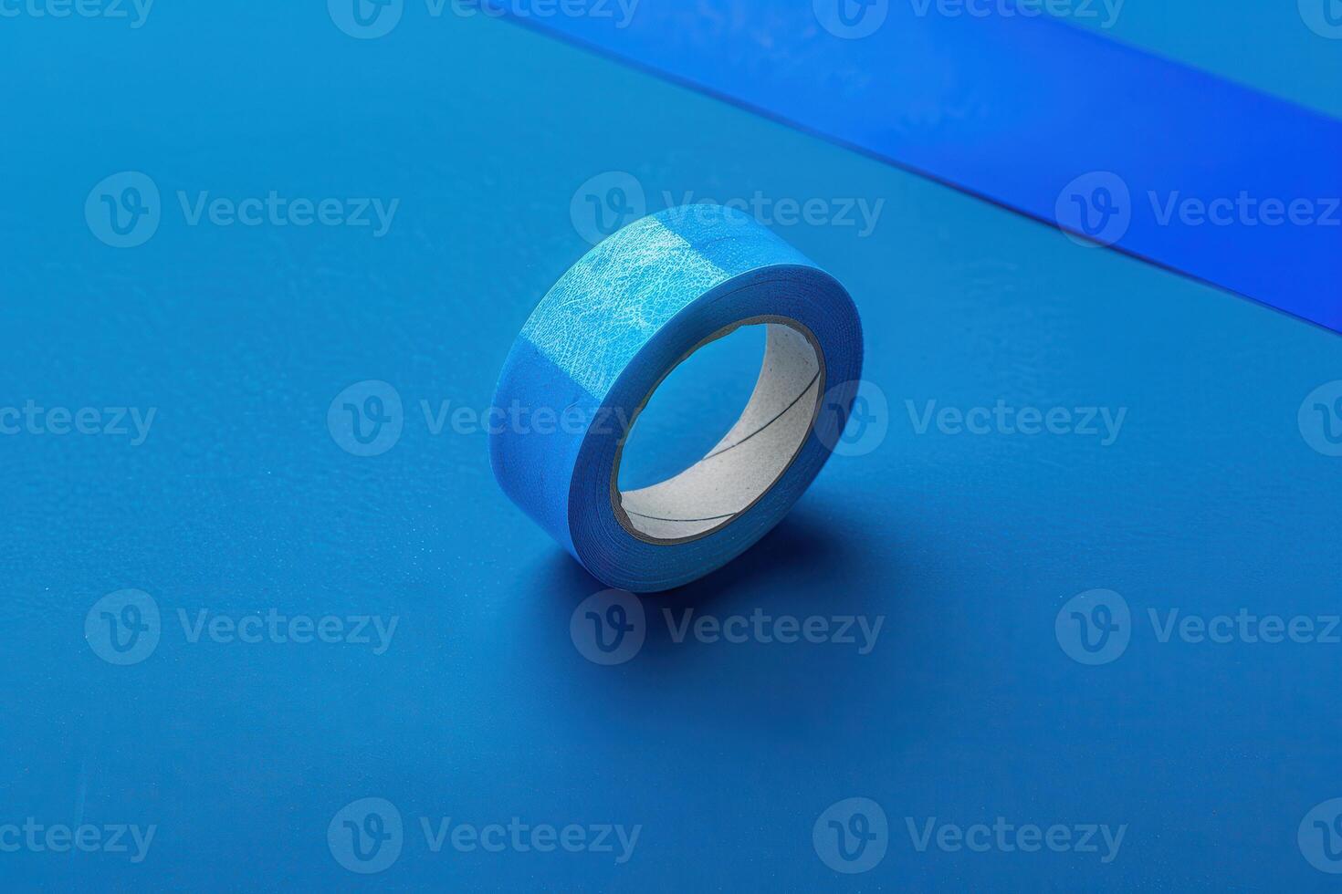 Blue masking tape on a vibrant blue background with additional tape strip photo