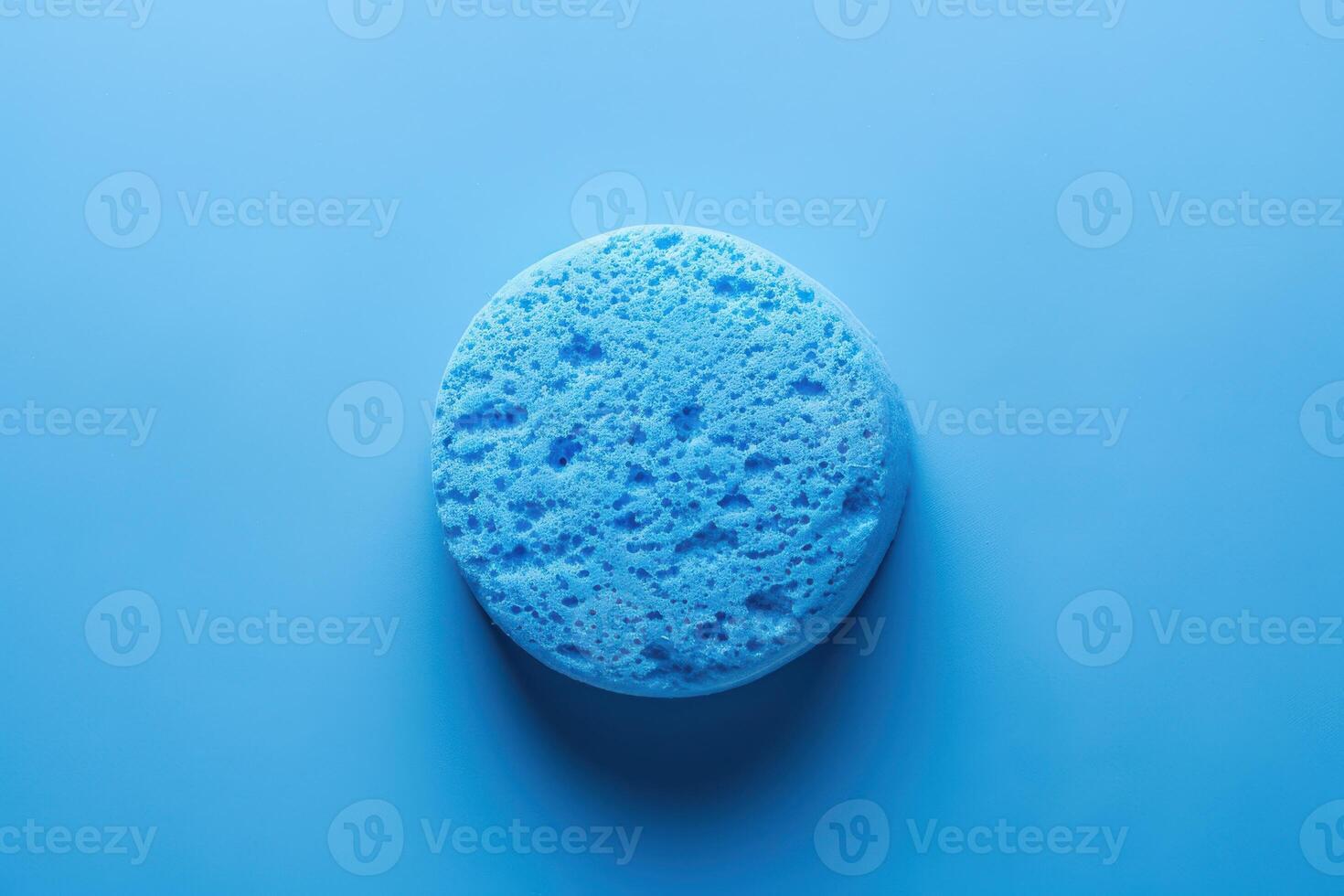 Blue sponge on a light blue background showcasing texture and color contrast photo