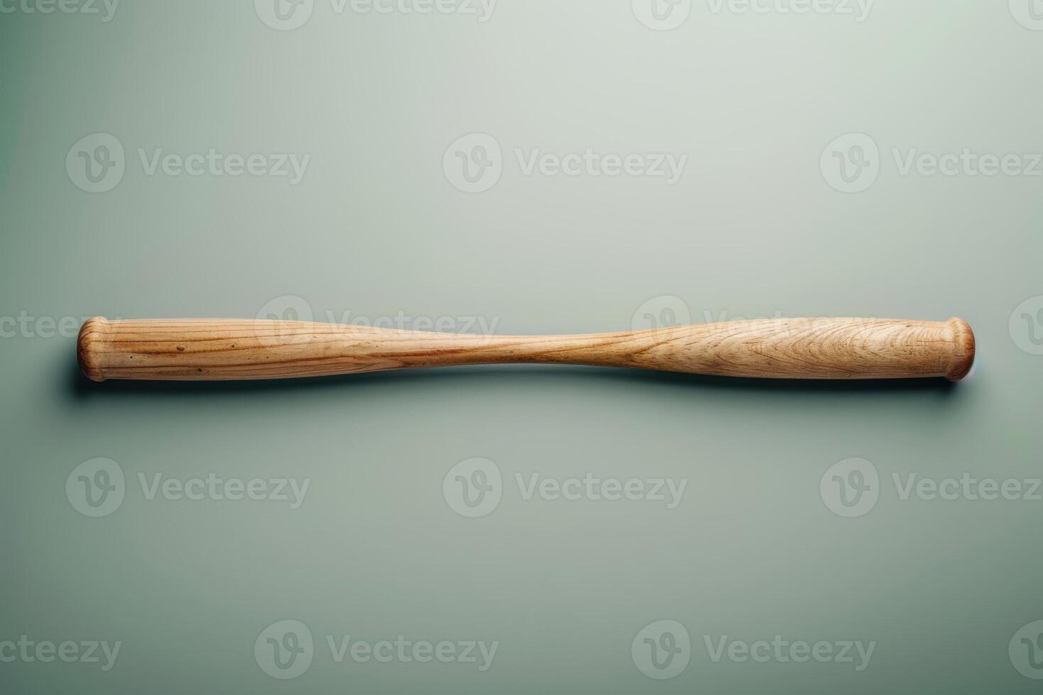 A wooden baseball bat lying flat on a green background in a minimalist setting photo