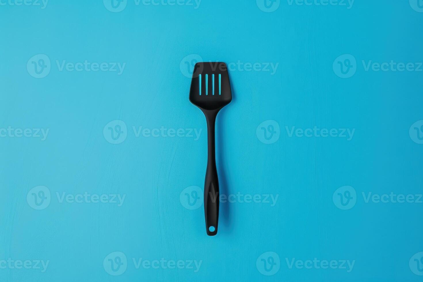 Black spatula on a blue background photo