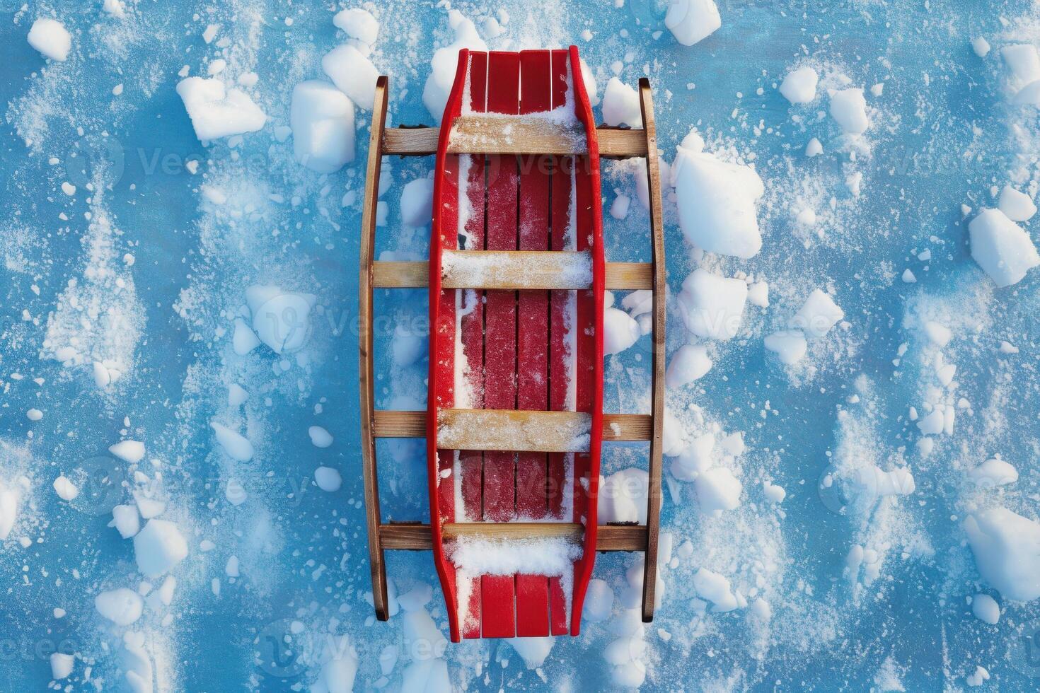 Red sled resting on snowy ice with scattered snowflakes during winter afternoon photo