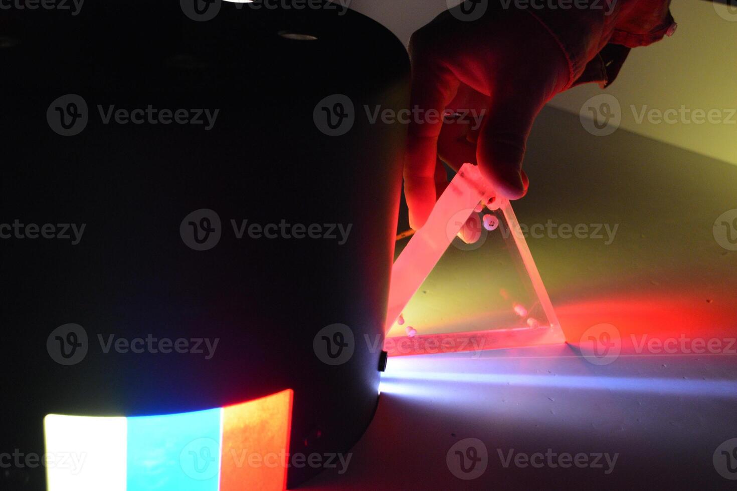 Transparent prism for experiments on light production in a hand. Concept of stylish technological background for sale or advertising photo