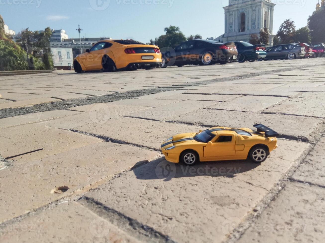 Toy yellow sports car stands on the ground in the background yellow sports car. Concept model of a stylish sports car. photo