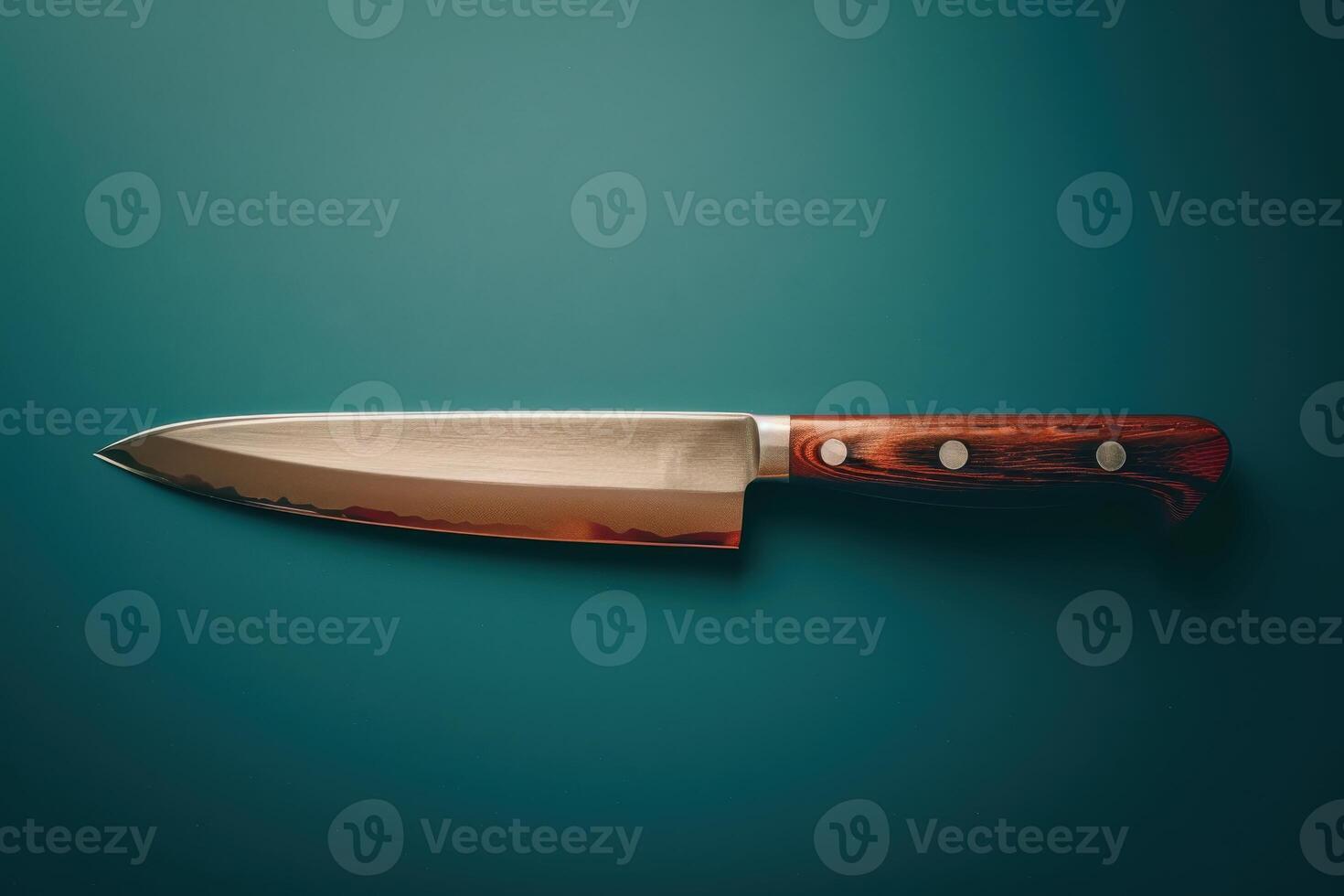 Sharpened kitchen knife resting on a teal countertop photo