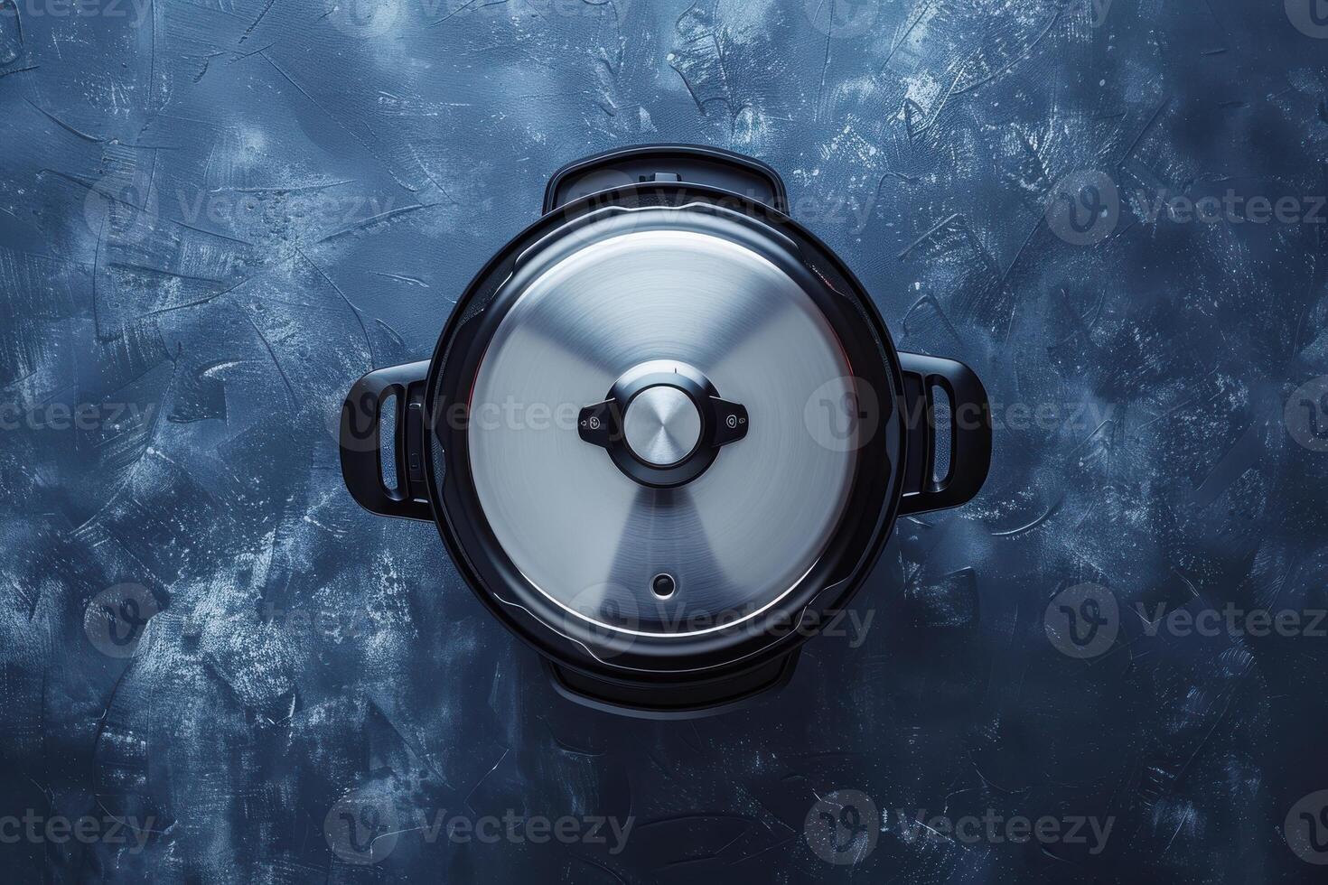 Top view of a stainless steel cooking pot on a textured blue surface photo